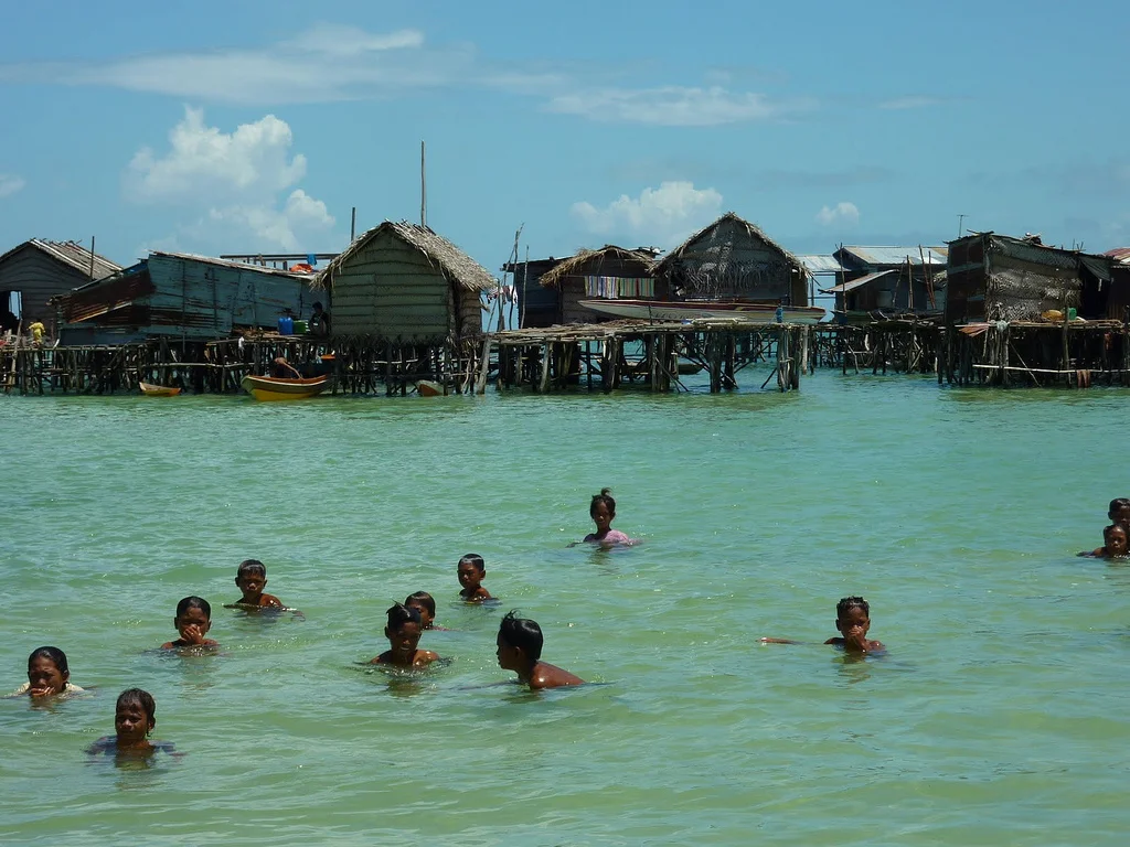 Bajau children swim in front of their village : Torben Venning