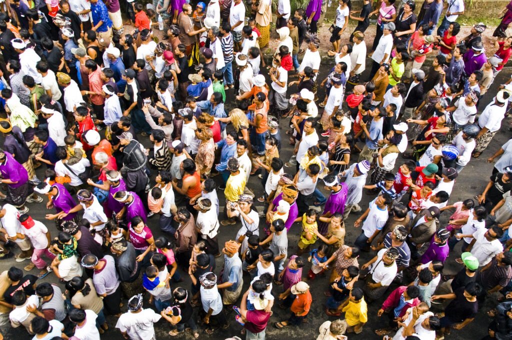Quality healthcare, education and work are all vital to harvest the full benefits of a demographic dividend. : ‘Crowd down the street’ by TheBigTouffe is available at https://bit.ly/3UPeiE5 Licensed under CC BY 2.0