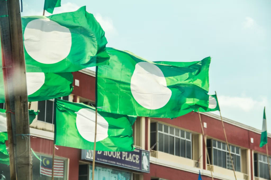UMNO and PAS are traditional rivals but have aligned before when political interests were mutual. : ‘PAS flags’ by Sham Hardy is available at https://tinyurl.com/zsatmd7f CC BY-SA 2.0
