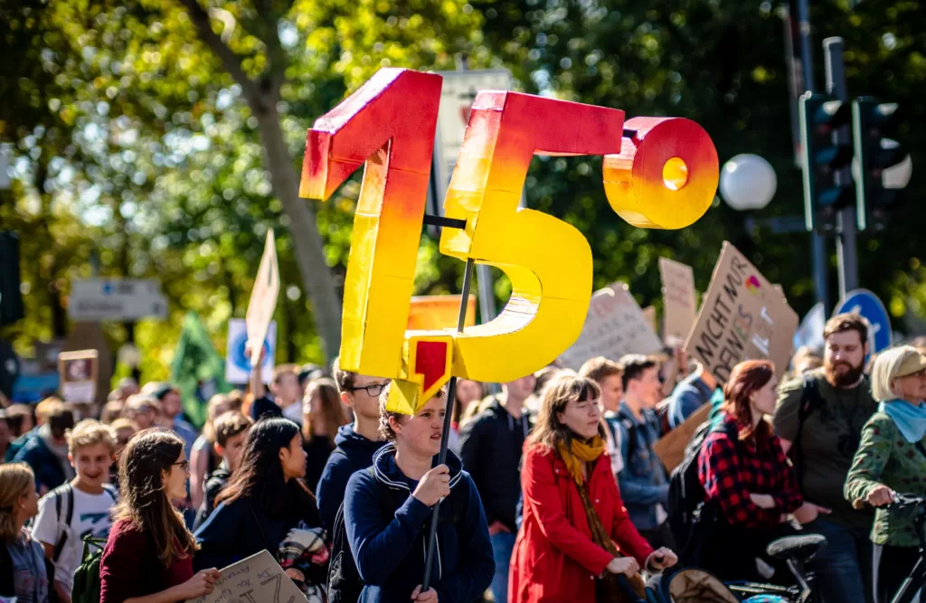 COP plays a crucial role to pressure governments to act to keep climate warming to 1.5 degrees, or within 2 degrees. : Mika Baumeister via Unsplash (https://unsplash.com/photos/group-of-people-standing-near-trees-jXPQY1em3Ew) Unsplash Licence